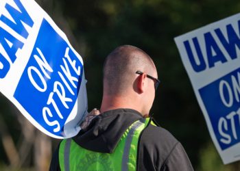 Striking autoworkers want to end a system that pays different wages for the same job