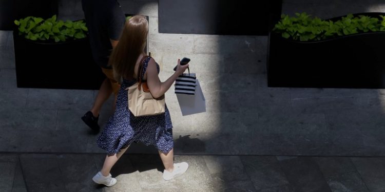 Americans are unusually down on a solid economy. So far, they aren’t spending — or voting — like it.